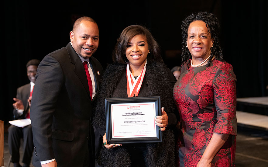 Courtney Johnson holds up her award