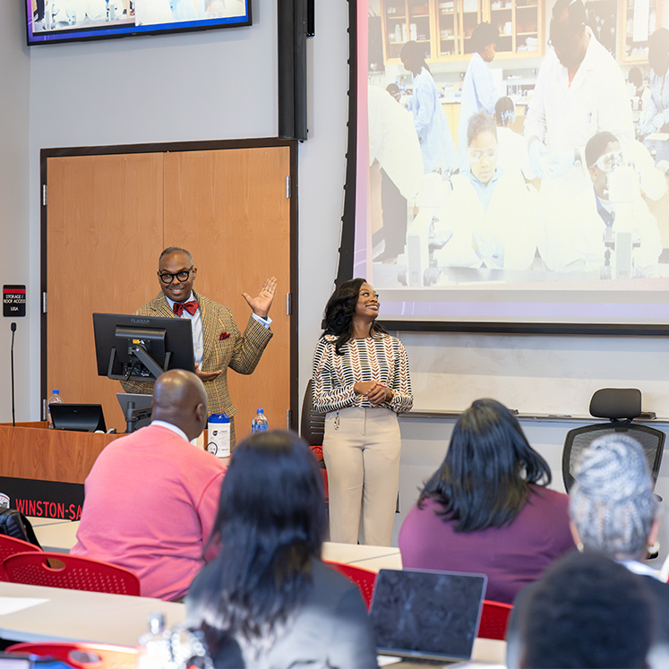 two professionals in front of a class