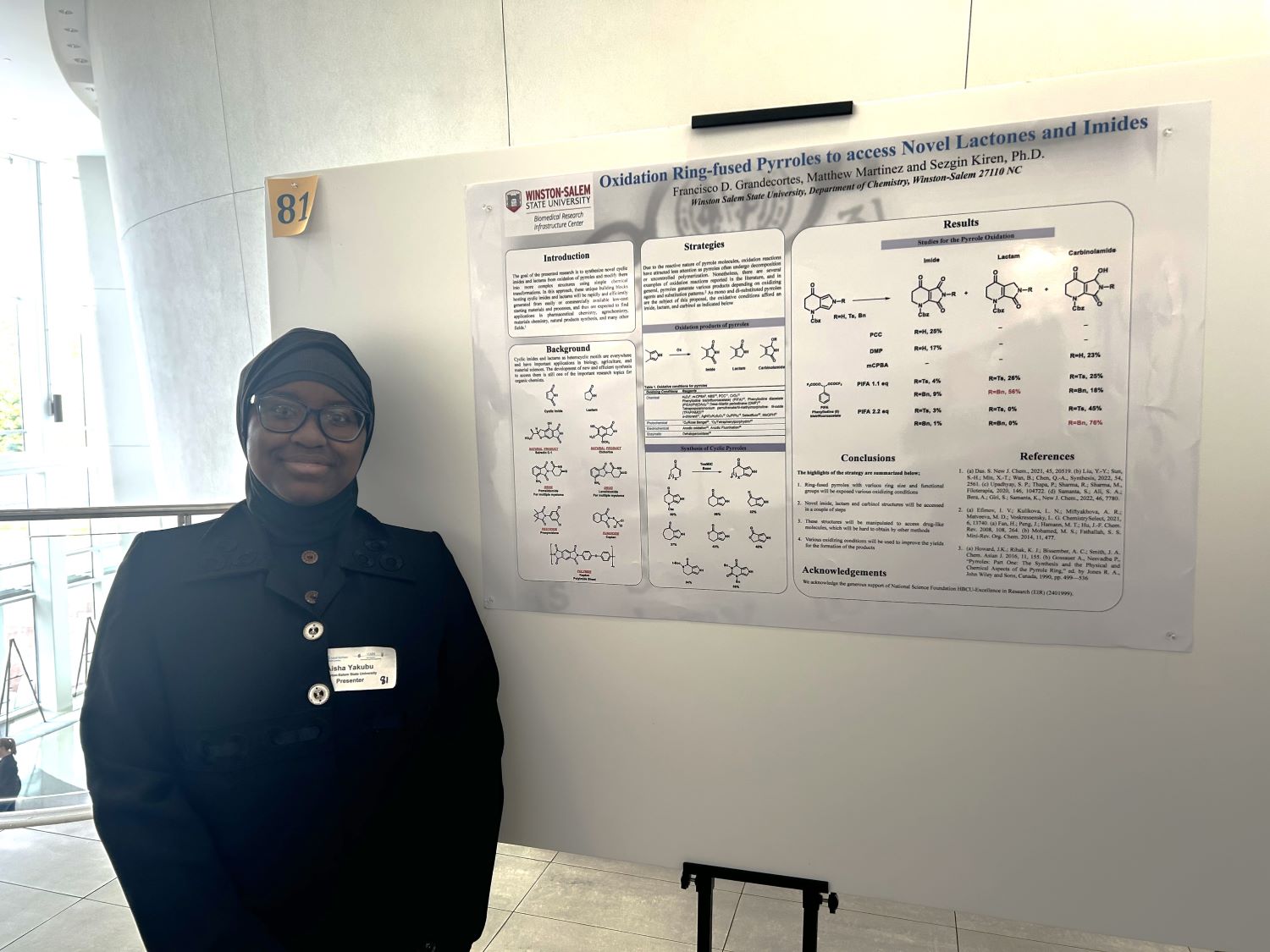 Student stands next to her research poster